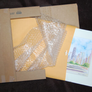 Photo of a matted print fitted into a corrugated free shipping box for transportation.