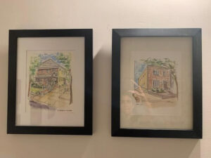 Photograph of both framed house portraits done for Anne Campbell by artist Stephen F. Condren.